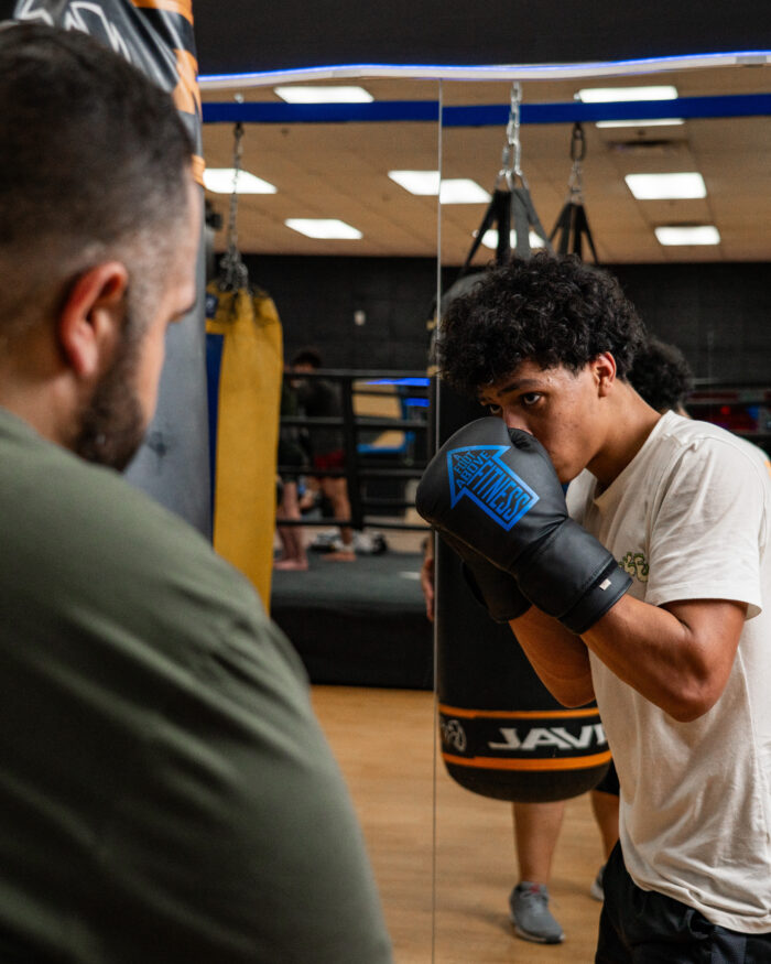 Coach Nick in the Arrows Boxing Club Coach Nick and his client practicing in the boxing gym at A Foot Above Fitness